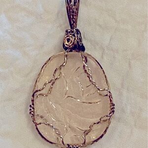 Etched glass necklace with pink tint.